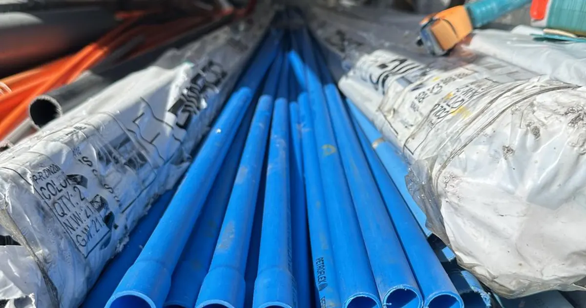 Tubos de PVC azules apilados en la bodega de la ferretería